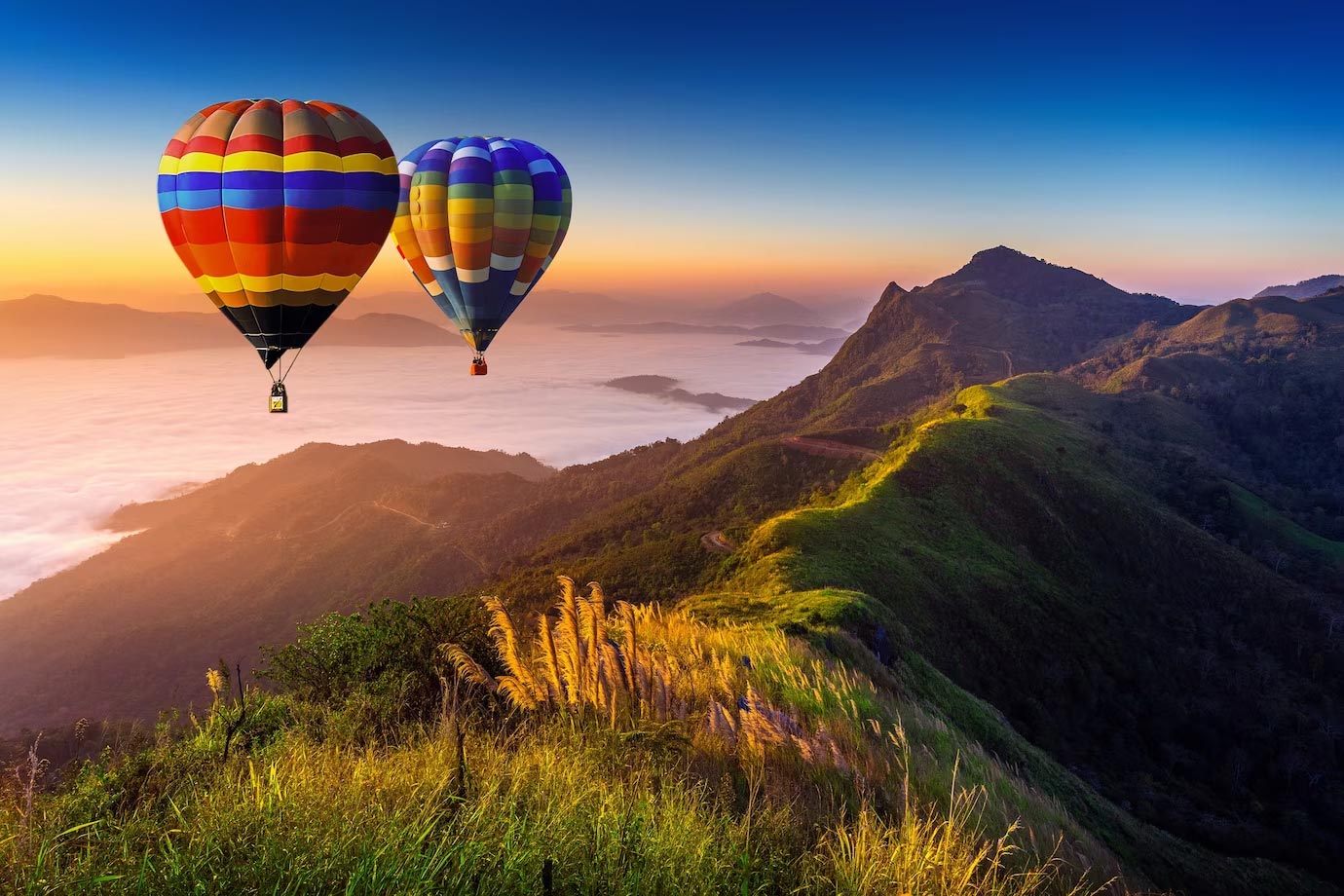 Hot air balloons floating above a dramatic mountain landscape